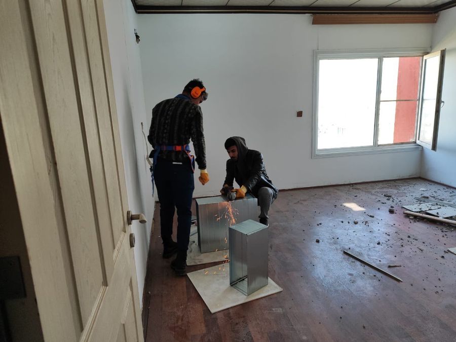 Trainees cutting sheet-metal ducting during vocational training